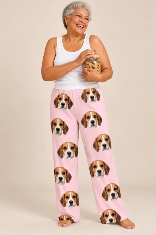 Laughing woman hugging a jar of dog treats in blush pink beagle pajamas womens against a tan studio wall