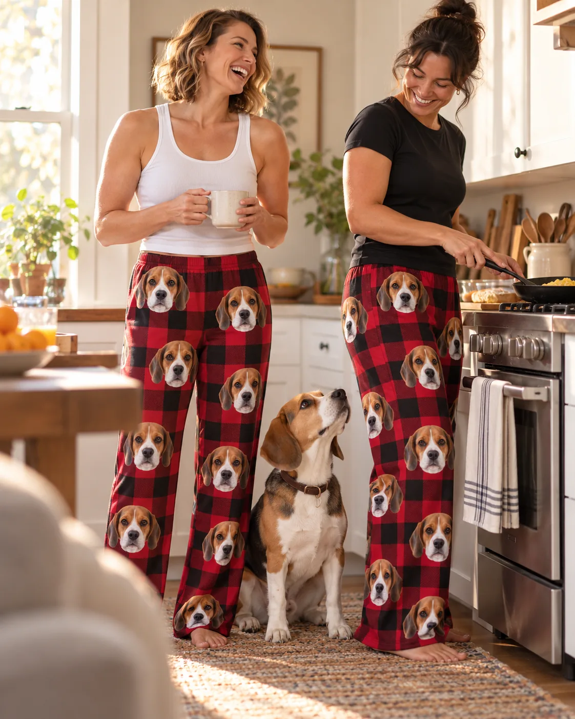 Two friends laughing in a kitchen in red plaid beagle pajama pants while their beagle begs for breakfast