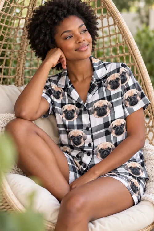 Woman in a hanging rattan chair wearing black and white plaid pajama shorts with pug faces