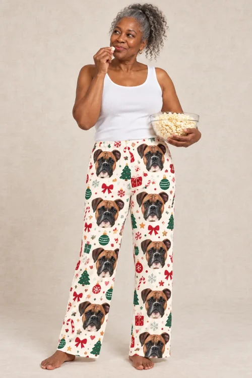 Woman snacking on popcorn in Christmas Cream boxer dog pajamas, beige studio