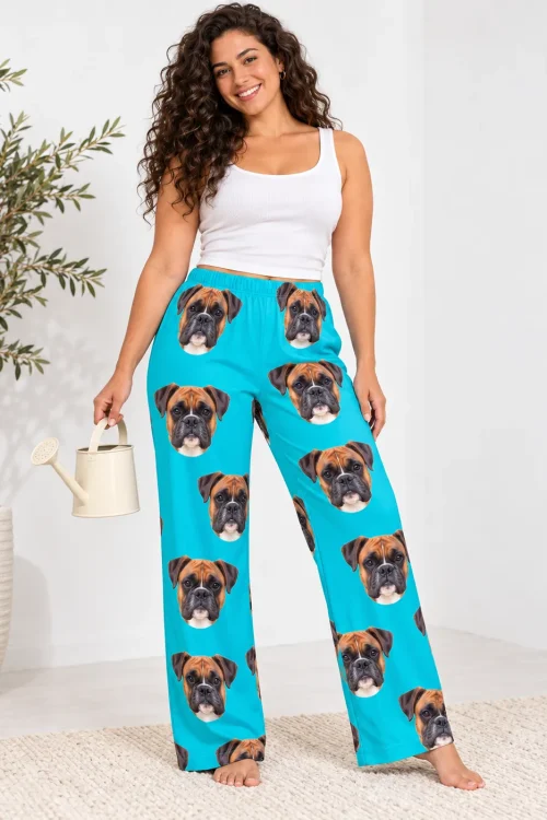 Curly-haired woman holding a watering can in teal boxer dog pajama pants, white studio