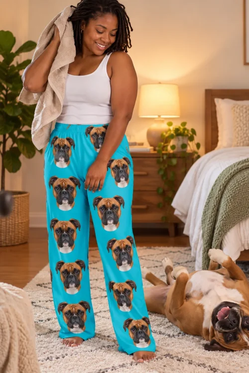 Woman with a towel smiling at her boxer rolling on the rug, in teal boxer dog pajamas