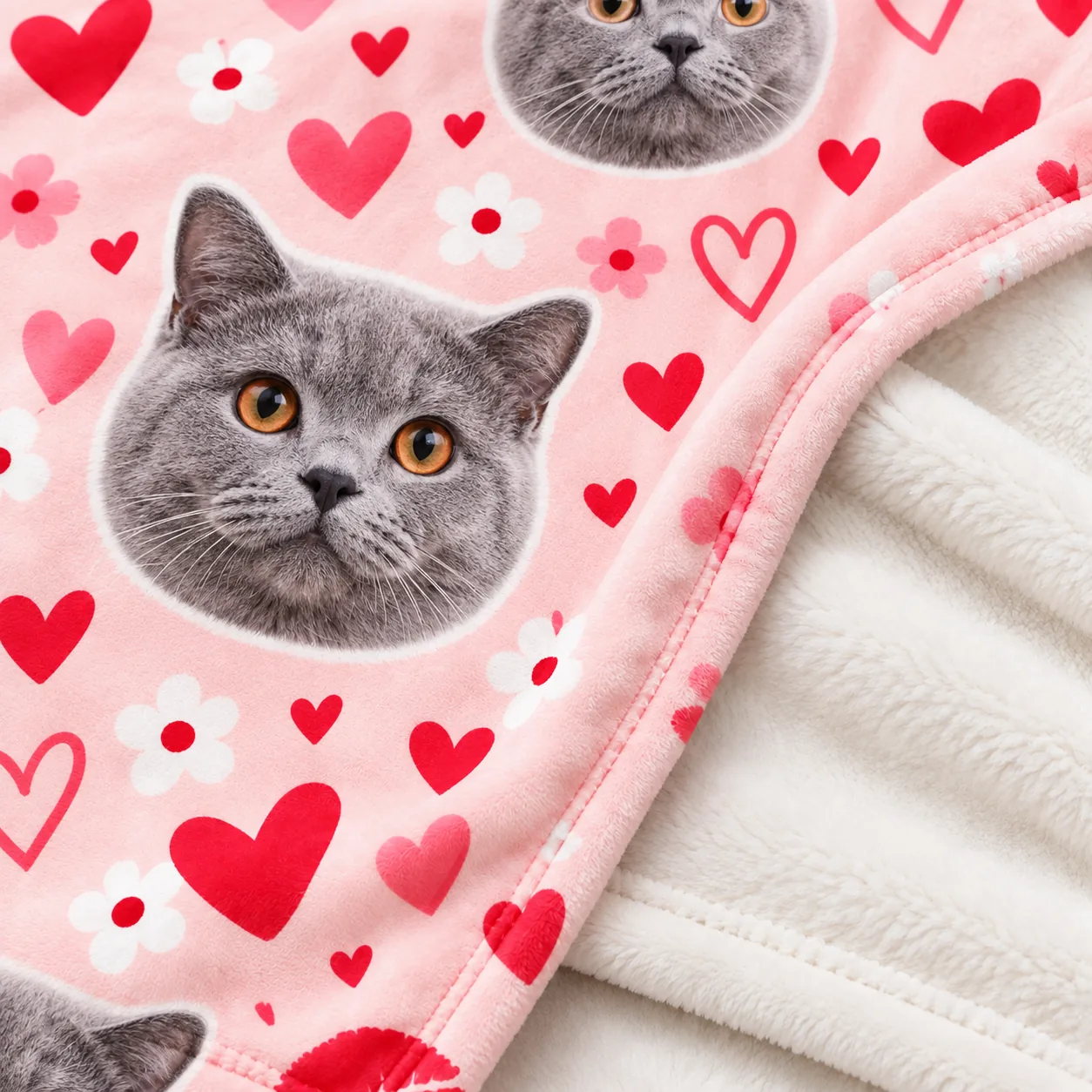 Close-up of a pink minky photo blanket for cat lovers, printed with a gray British Shorthair's face and hearts