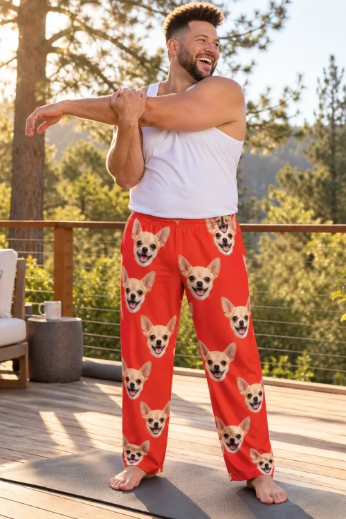 Man stretching on a yoga mat on a sunny wood deck among pine trees, in red chihuahua pajama pants
