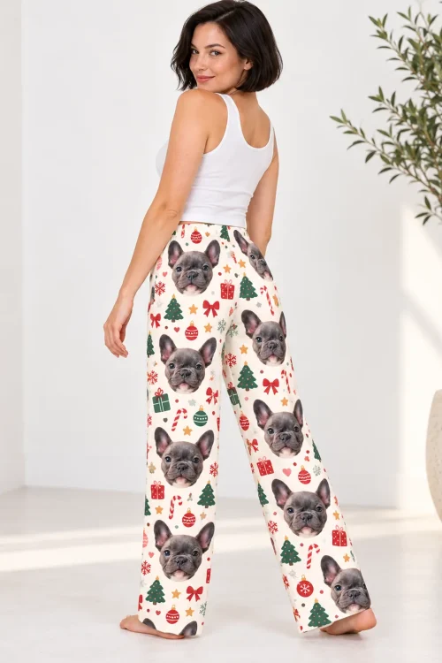 Woman looking over her shoulder in cream Christmas pajama bottoms printed with French bulldog faces