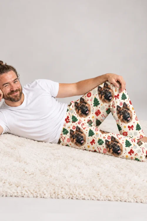 Man lying on a shaggy rug in cream Christmas pajamas for men with German Shepherd faces and candy canes