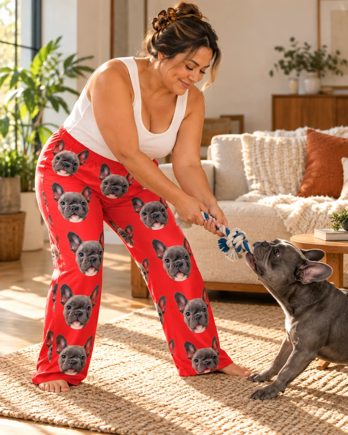 Pet face pajamas: woman playing tug-of-war with a French bulldog, wearing red pajama pants printed with its face