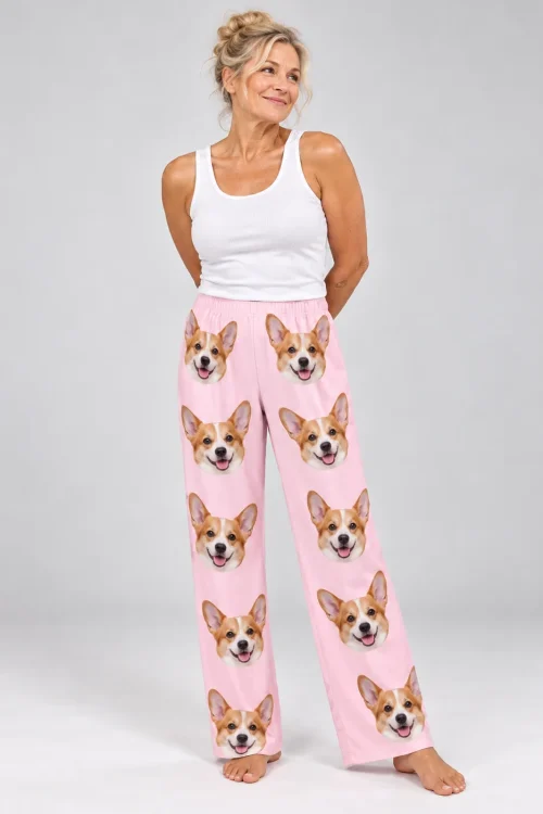 Smiling woman in a white tank and blush pink corgi pajamas for women, barefoot in a light gray studio