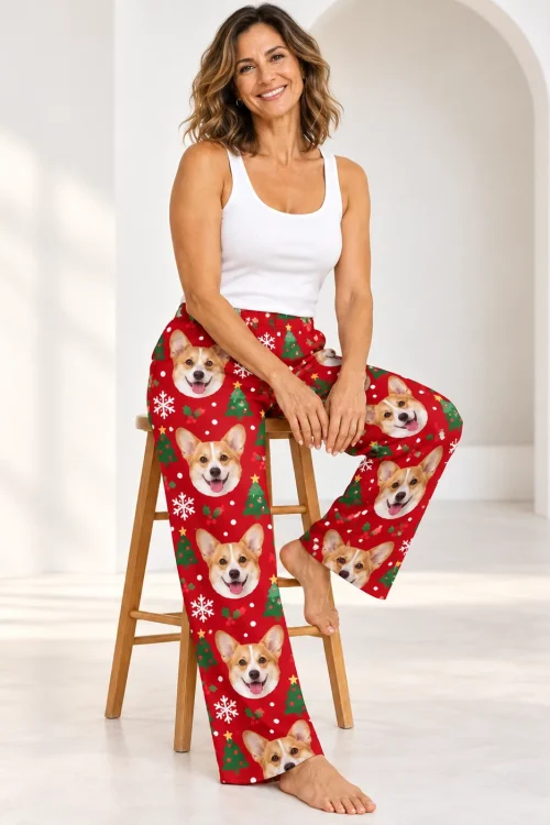 Smiling woman on a wooden stool in a white studio wearing red Christmas corgi pajamas for women