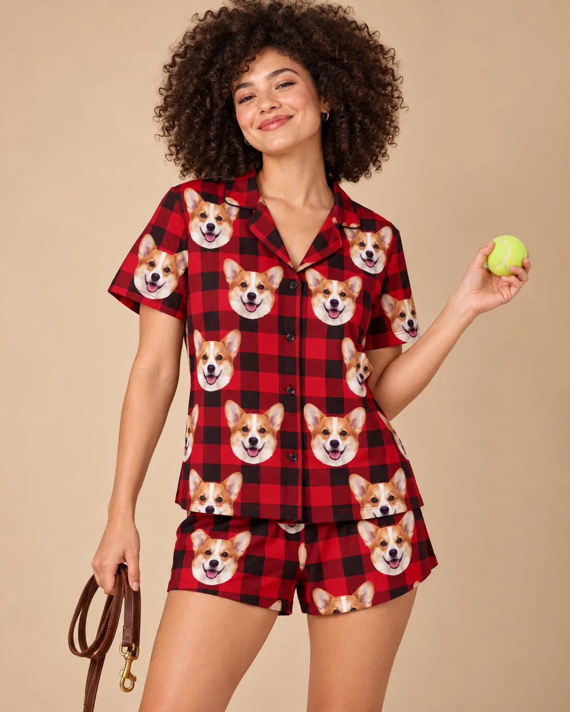 Custom Corgi Short Pajama Set — red plaid studio | GenzOutfit Woman holding a tennis ball and a leash in a red plaid corgi pj set against a warm tan backdrop