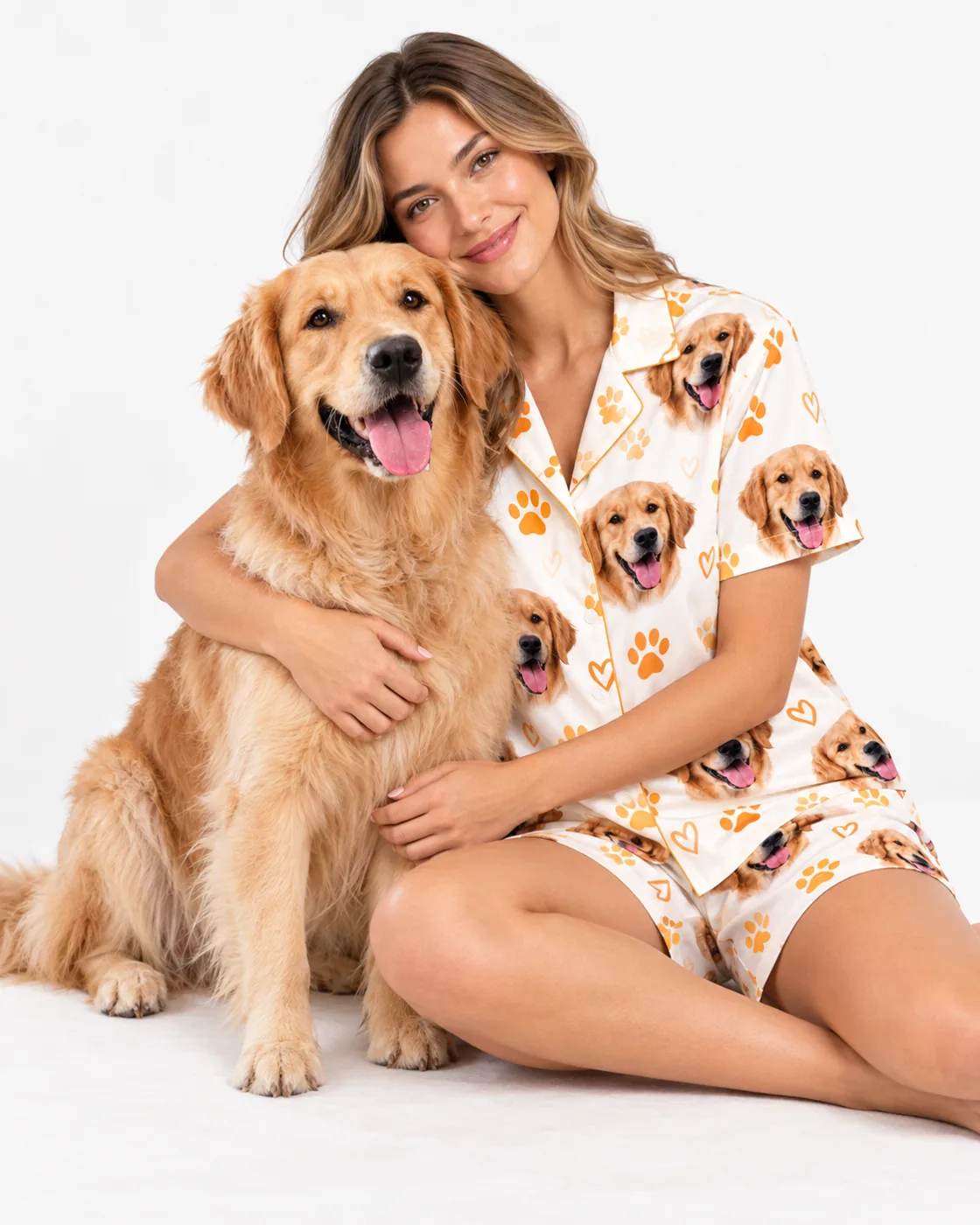 Woman hugging her golden retriever while wearing a short pajama set printed with the dog's face