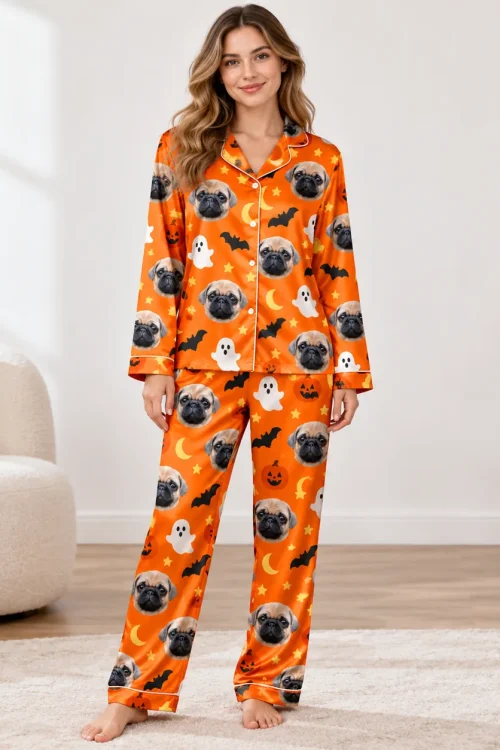Woman in a custom pet pajama set: orange satin printed with pug faces, ghosts and pumpkins