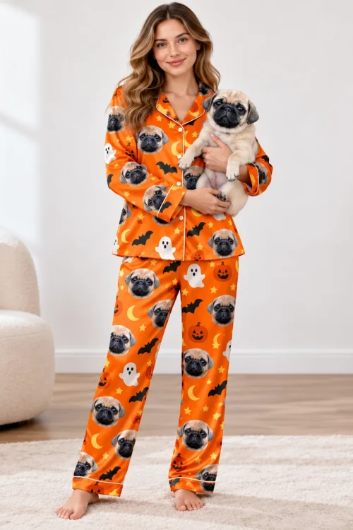 Woman holding her pug while wearing a satin pajama set printed with the pug's face