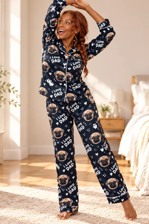 Woman stretching in a sunny bedroom in a navy I Love Dad satin pajama set with pug faces