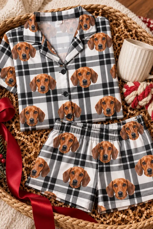 Folded white plaid dachshund pajama set in a gift basket with a red ribbon, a mug and a rope toy