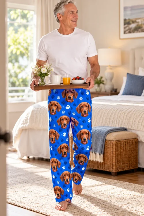 Gray-haired man carrying a breakfast tray in a bright bedroom, wearing royal blue paws dachshund pajamas