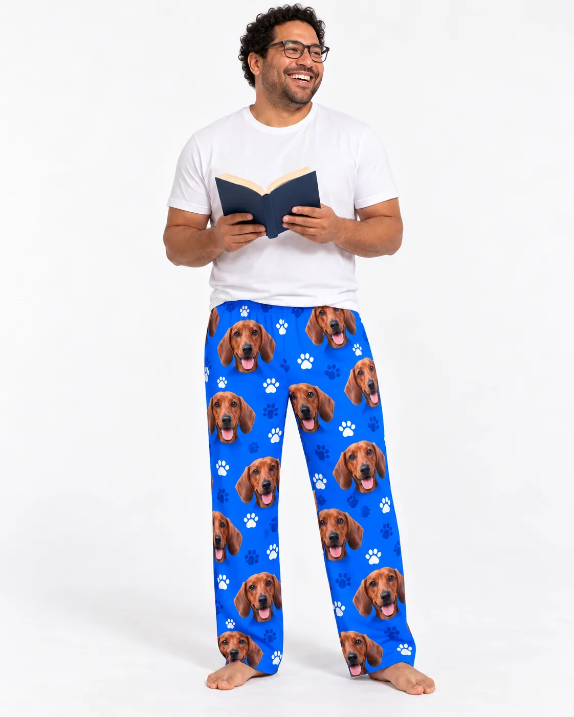 Men's Custom Dachshund Pajama Pants — royal blue paws studio | GenzOutfit Smiling man in glasses reading a book, wearing royal blue paws men's dachshund pajama pants