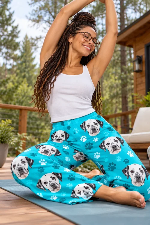 Woman in glasses stretching on a yoga mat on a cabin deck in teal paws dalmatian pajama pants