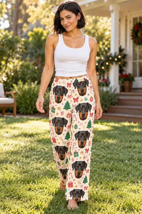Woman strolling across a sunny lawn in Christmas cream doberman pajama pants, porch wreath behind