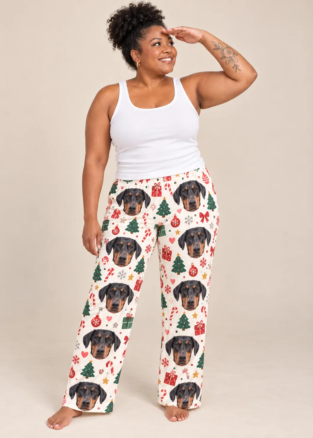 Custom Doberman Pajama Pants for Women — christmas cream studio | GenzOutfit Woman shading her eyes in Christmas cream doberman pajamas for women with trees and candy canes