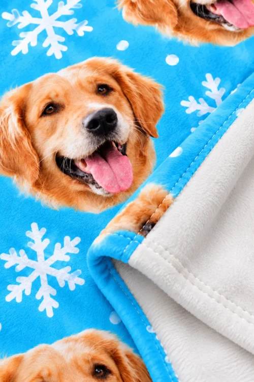 Close-up of the dog face fleece blanket: golden retriever face, snowflakes and white back