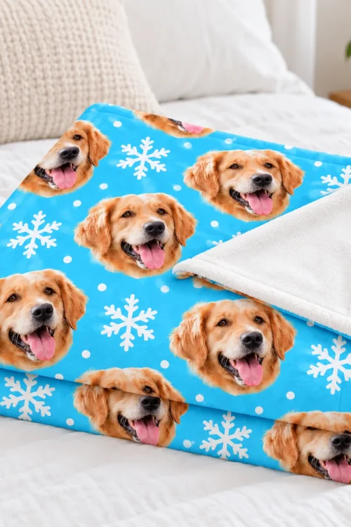 Folded dog face fleece blanket on a bed with the soft white back showing