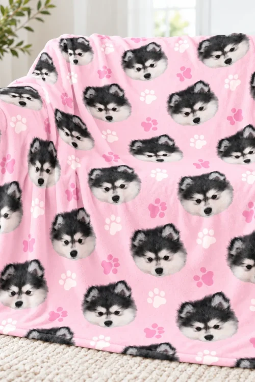 Dog face minky blanket draped over a sofa, husky puppy and pink paw print
