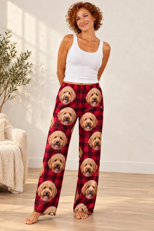Woman with curly red hair standing in red plaid doodle pajama pants printed with goldendoodle faces