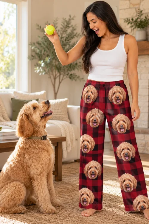 Woman holding a tennis ball for her goldendoodle in red plaid doodle pajama pants in a sunny living room