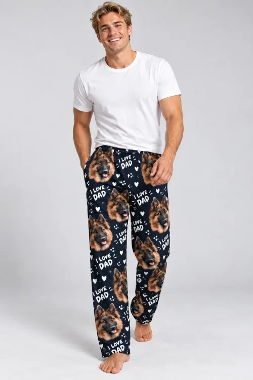 Smiling man in navy I Love Dad Father's Day pajama pants with German Shepherd faces on a grey backdrop
