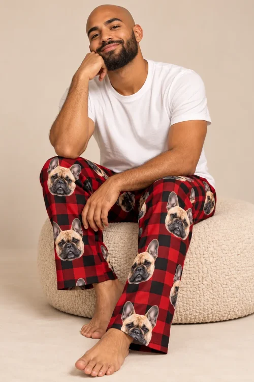 Bearded man sitting on a cream pouf in red plaid French bulldog pajama pants