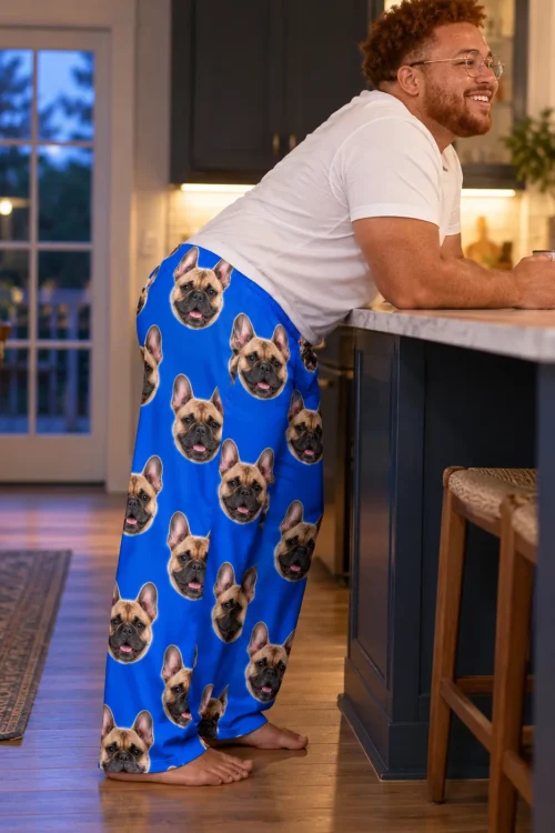 Man leaning on a kitchen island at dusk, side view of royal blue men's French bulldog pajama pants