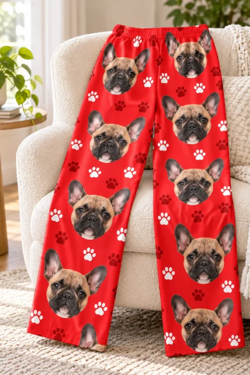 Red paws French bulldog pajamas for women draped over a cream armchair, faces down both legs
