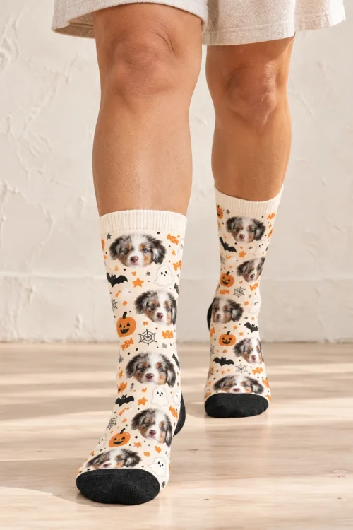 Legs walking across a sunny floor in cream Halloween funny dog socks with puppy faces