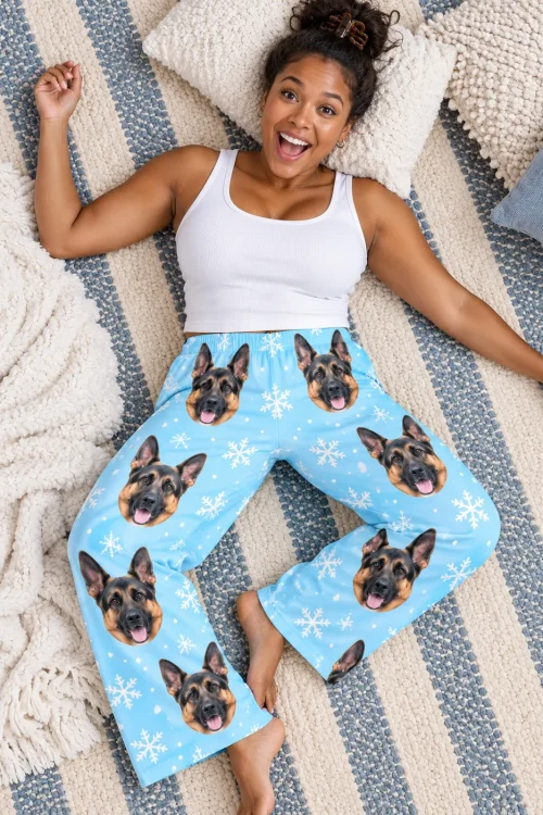 Woman lying on a striped rug laughing, from above, in snowflake german shepherd pajama pants