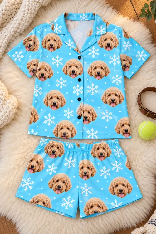 Snowflake golden doodle pajama set laid flat on a sheepskin rug with a dog collar and tennis ball