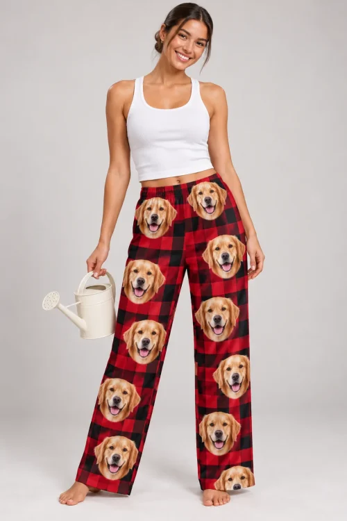 Woman holding a watering can in red plaid golden retriever pajama pants in a light gray studio