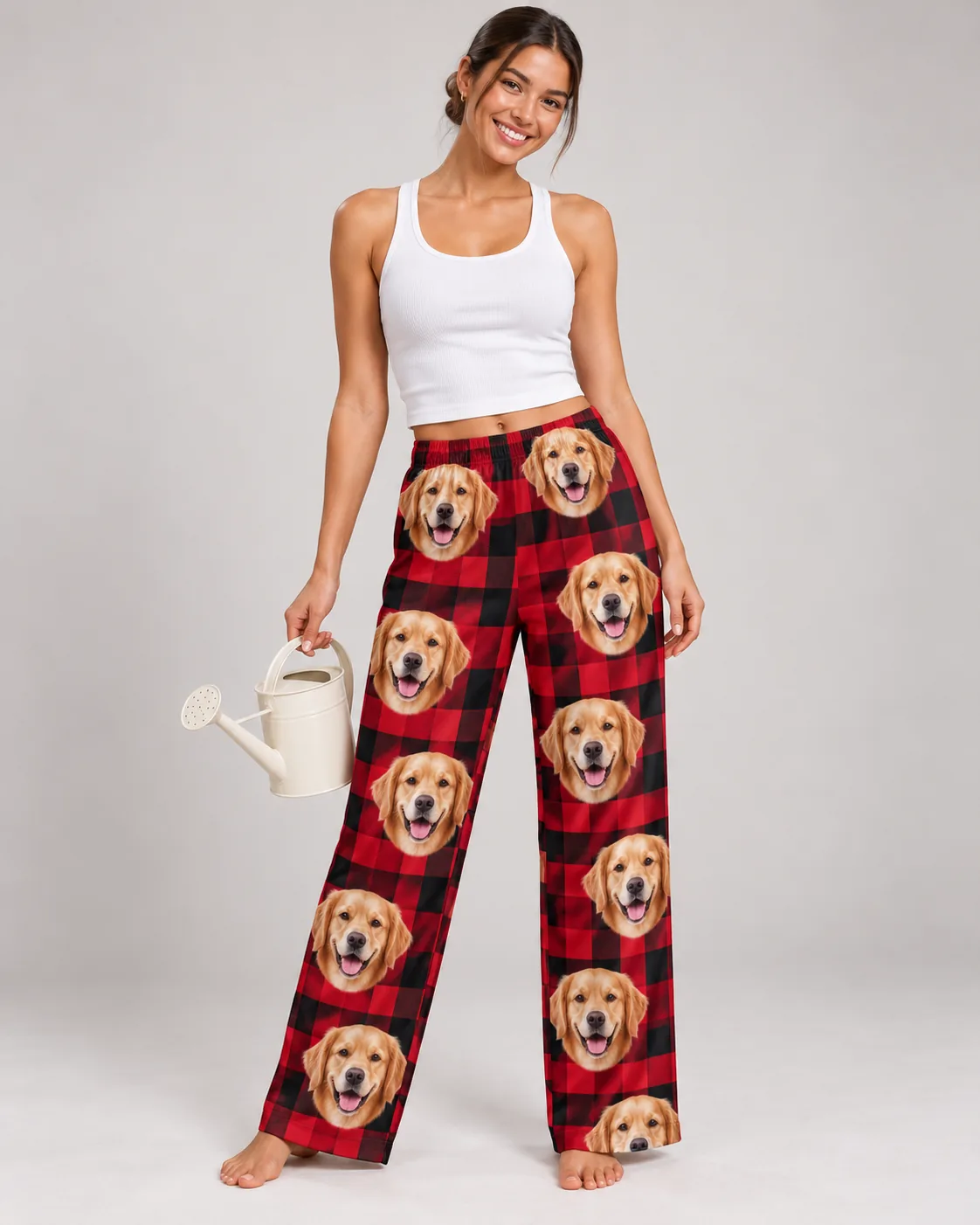 Custom Golden Retriever Pajama Pants for Women — red plaid studio | GenzOutfit Woman holding a watering can in red plaid golden retriever pajama pants in a light gray studio