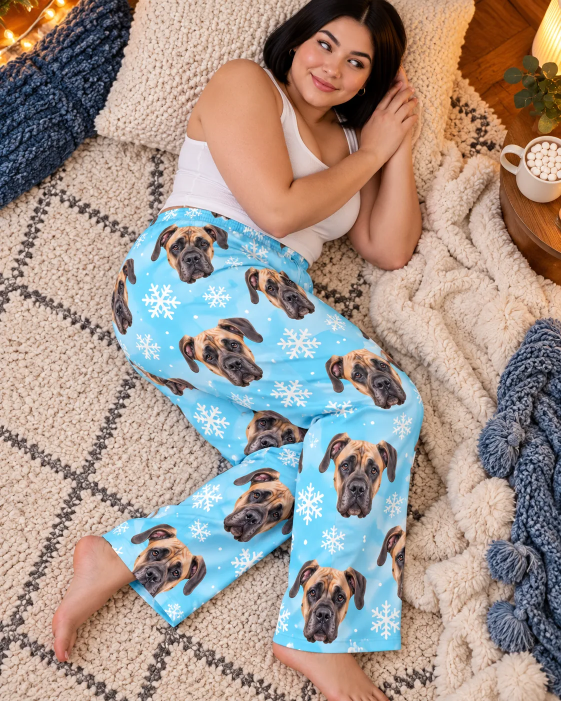 Custom Great Dane Pajama Pants for Women — snowflake detail | GenzOutfit Woman resting on a rug with a hot cocoa beside her in snowflake great dane pajama pants, from above