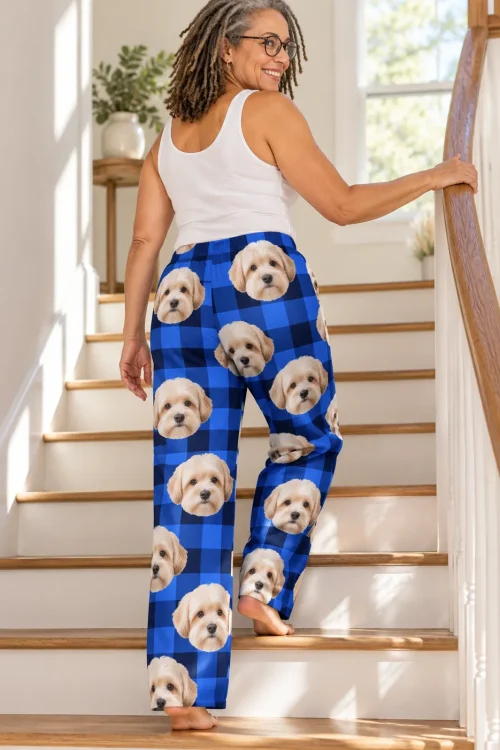 Woman climbing a staircase, back view of blue plaid havanese pajamas with dog faces on both legs