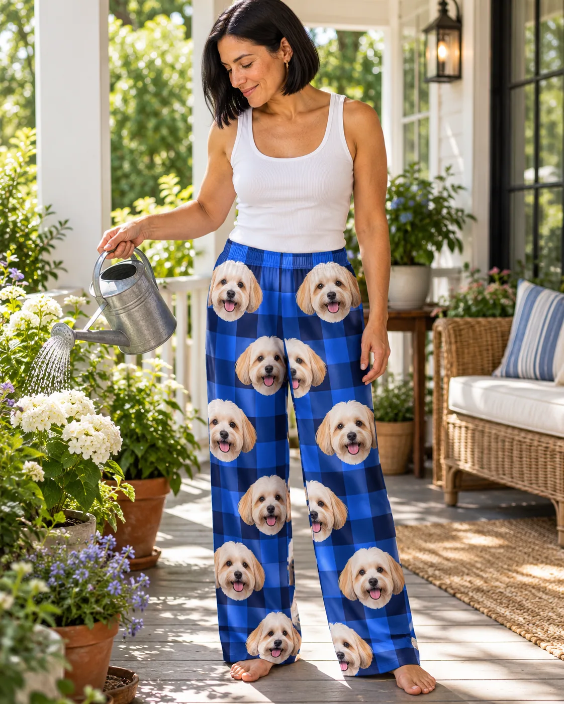 Woman watering porch flowers in blue plaid havanese pajamas printed with cream dog faces