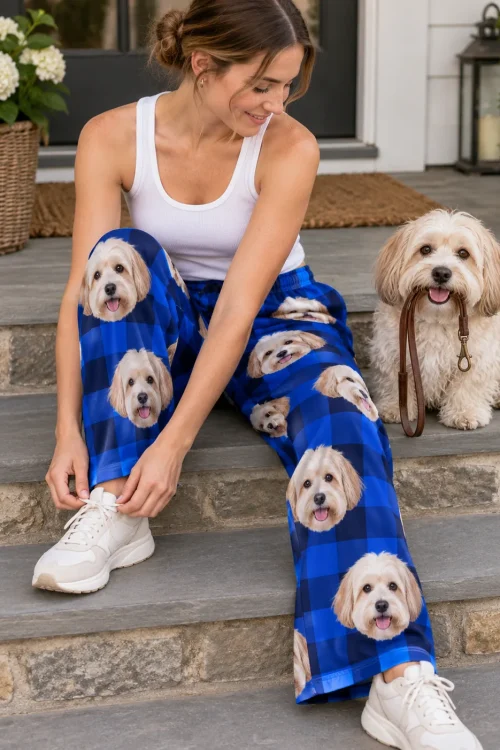 Woman tying her sneaker on stone steps in blue plaid havanese pajamas, her cream Havanese holding a leash