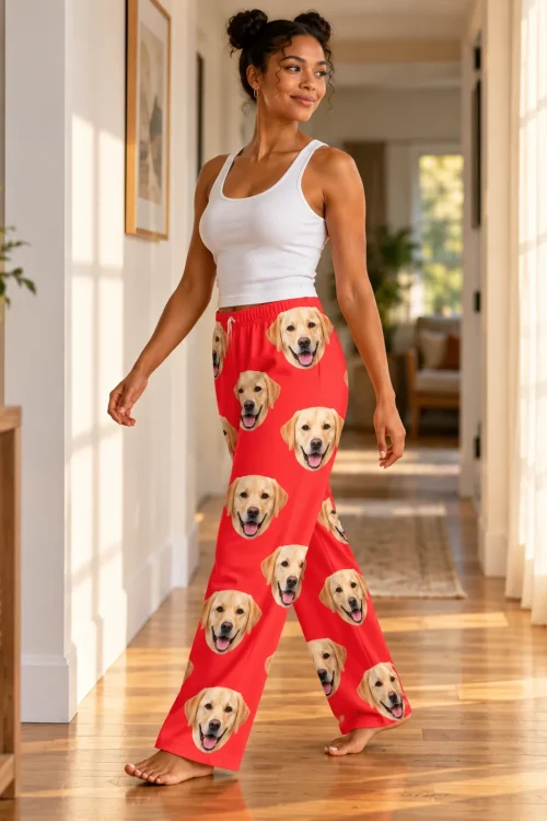 Woman walking down a sunny hallway in red pajama pants covered in yellow labrador faces