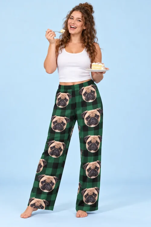 Woman eating cake in green plaid ladies pug pajamas against a light blue backdrop