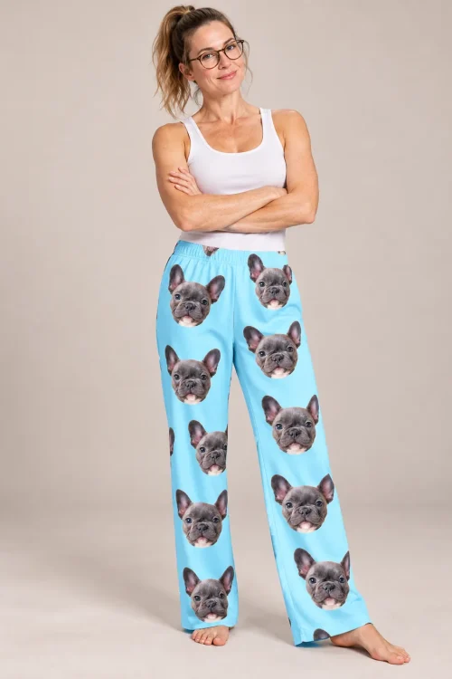 Woman in glasses with crossed arms in light blue pajama pants printed with French bulldog faces