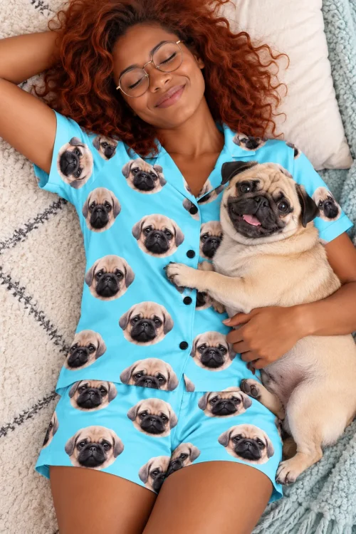 Woman with red curls napping on a blanket in a light blue pajama set, her pug on her chest