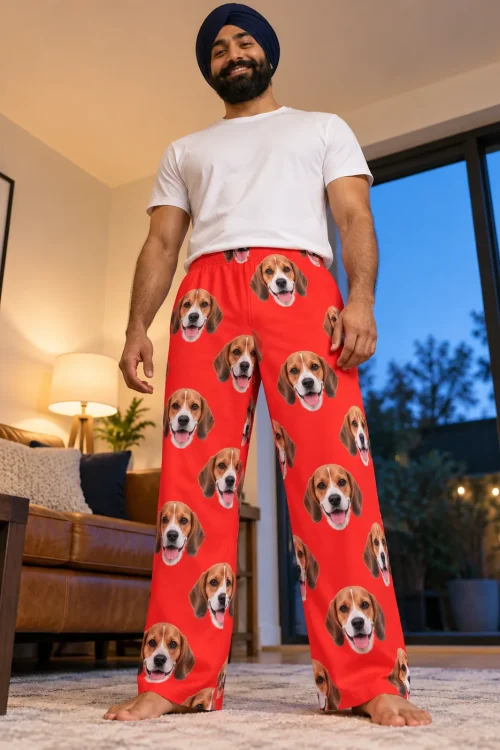 Smiling bearded man standing on a living room rug in red mens beagle pajamas, shot from a low angle