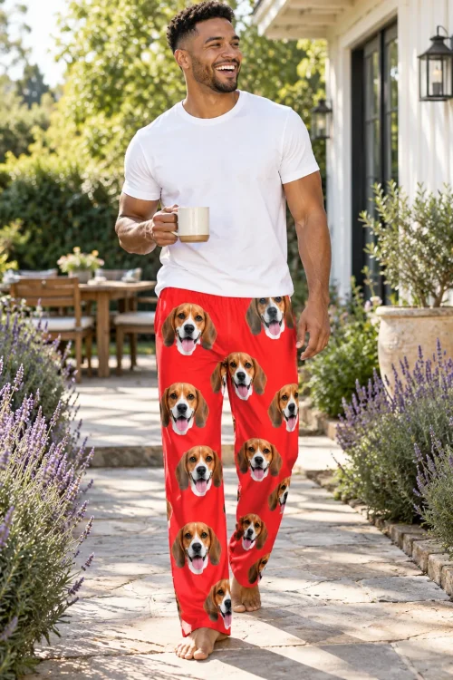 Man carrying a coffee mug along a lavender-lined garden path in red mens beagle pajamas