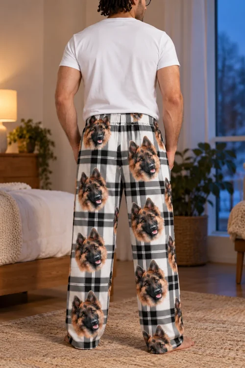 Back view of men's black and white plaid pajama pants with German Shepherd faces in a bedroom