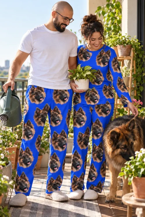 Couple in royal blue pajama pants with German Shepherd faces tending plants on a sunny balcony with their dog